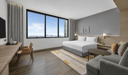 ジョホールバルにあるHyatt Place Johor Bahru Paradigm Mallのベッドとソファ付きのホテルルーム