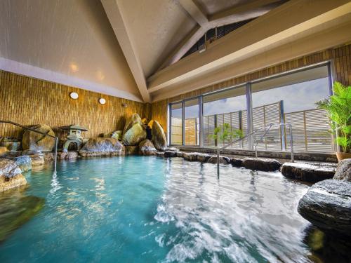 Yukai Resort Premium Koshinoyu في ناتشيكاتسورا: مسبح في غرفة مع نافذة كبيرة