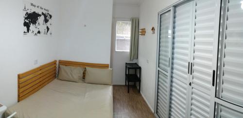 um quarto com uma cama e uma cabeceira em madeira em Suíte Independente - Praia Indaiá e Riviera - MarDoceLar Bertioga em Bertioga