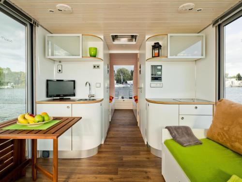 a kitchen and living room in a rv with a table at Houseboat on the Dahme in Niederlehme