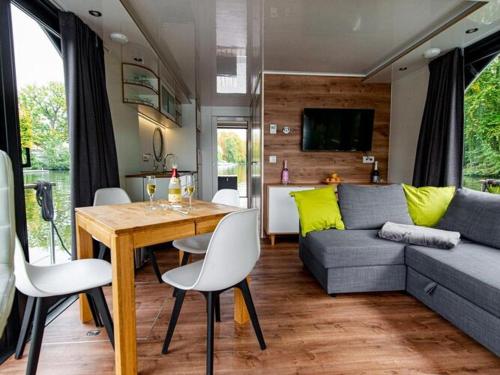 a living room with a table and a couch at Houseboat on the Dahme in Königs Wusterhausen