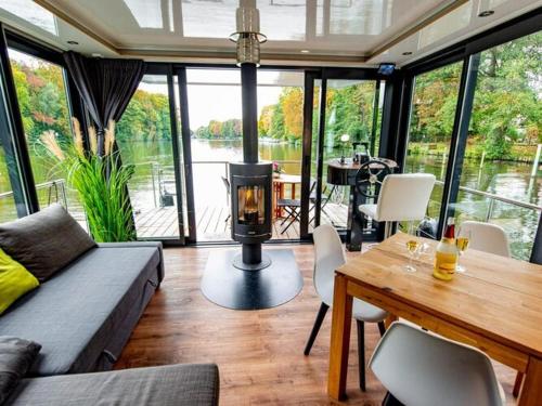 a living room with a fireplace and a table with chairs at Houseboat on the Dahme in Königs Wusterhausen