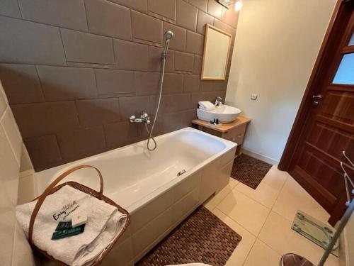 a bathroom with a bath tub and a sink at Holiday house with sauna and garden, Pobierowo in Pobierowo