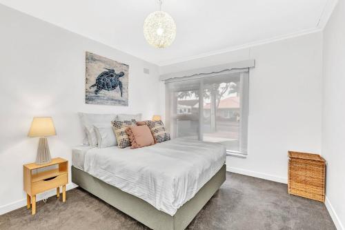 a bedroom with a bed and a window at Beachtown Breeze - A Coastal Gem in Glenelg East in Glenelg