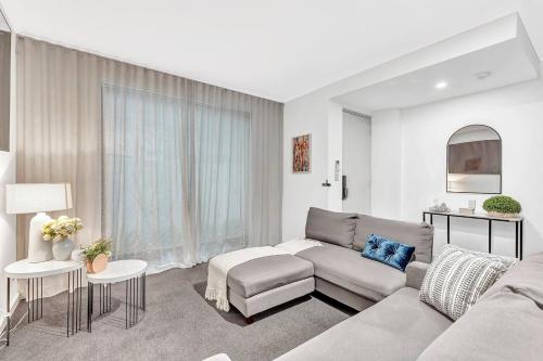 a living room with a couch and a table at Stellar - Spacious Rooftop Dreamscape in Adelaide in Rose Park