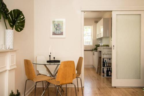a dining room with a glass table and chairs at Cranbrook Courtyard - A Sunny City-fringe Retreat in Adelaide