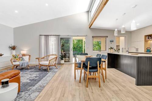 a kitchen and living room with a table and chairs at 'Chimney Cottage' Family Gem where Beach meets Port in Adelaide