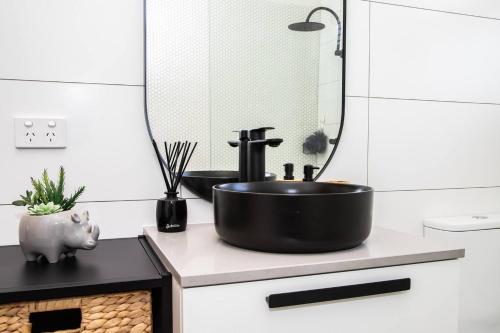 a bathroom with a black sink on a counter at Cranbrook Courtyard - A Sunny City-fringe Retreat in Wayville