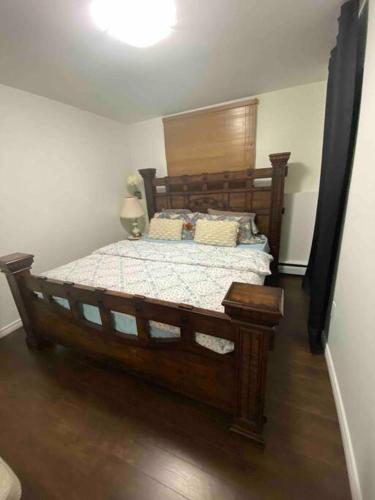 a bedroom with a large wooden bed in a room at Beautiful two bedroom apartment. in Calgary