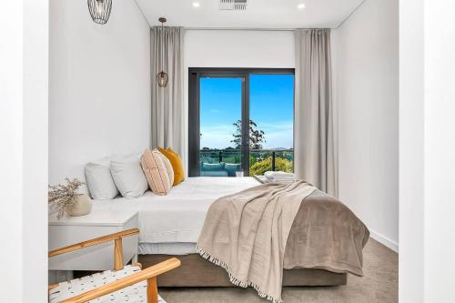 a bedroom with a bed and a large window at 'The Outlook' Light-filled Nordic Contemporary in Glenunga