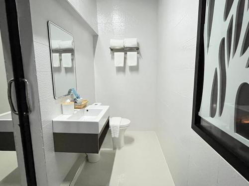 DM Hotel & Cafe في Ban Na Tho: حمام أبيض مع حوض ومرحاض
