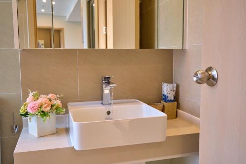 a bathroom with a sink and a vase of flowers at VIP THE SÓNG APARTMENT NEAR THE BEACH 5 STAR - FREE INFINITy in Vung Tau