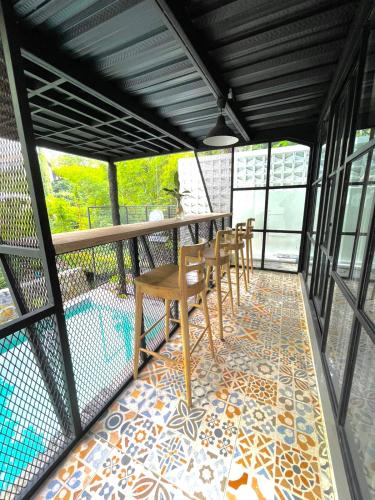 a balcony with a table and chairs on a mosaic floor at Sampai Villa Ruang Tepi in Yogyakarta