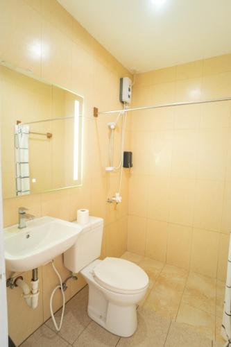 a bathroom with a toilet and a sink and a mirror at Casa Cecilia in El Nido
