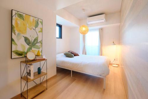 1 dormitorio con 1 cama y una pintura en la pared en Modello Sangenjaya, en Tokio
