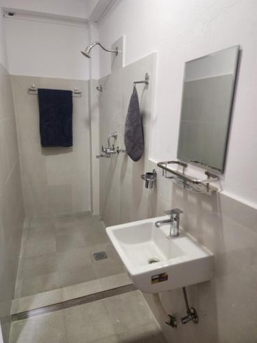 a white bathroom with a sink and a mirror at The Heritage at Lamakhet Hotel in Beni