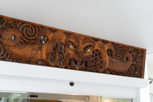 a wooden carving on the wall of a building at Hotel Armitage and Conference Centre in Tauranga