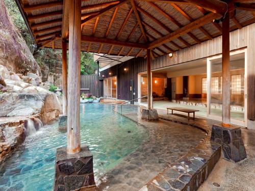 una piscina con cascada en una casa en Yukai Resort Premium Shirahama Saichoraku, en Shirahama