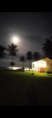 a house with palm trees at night with a light at Baan Be Beach in Lang Suan