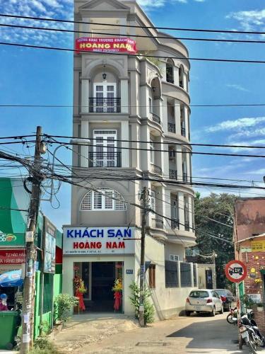 um edifício branco alto com um cartaz em Hoàng Nam - 617 Nguyễn Thị Định, Q2 - by Bay Hostel em Ho Chi Minh