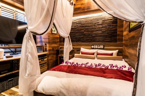1 dormitorio con 1 cama con dosel en Petit Bali Forest Shinjuku Sanchōme en Tokio