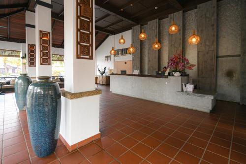 a restaurant with a lobby with vases on the floor at Adena Beach Resort in Kuantan
