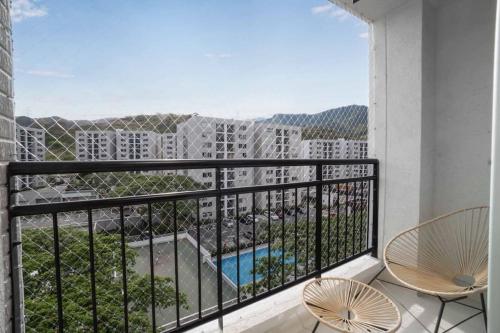 a balcony with chairs and a view of a building at Apto en Ciudad Guabinas - via Cali -Yumbo con piscina y Aires in Yumbo