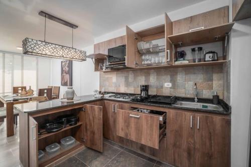 a kitchen with wooden cabinets and a sink at Apto en Ciudad Guabinas - via Cali -Yumbo con piscina y Aires in Yumbo