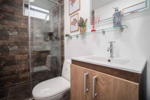 a bathroom with a toilet and a sink and a shower at Apto en Ciudad Guabinas - via Cali -Yumbo con piscina y Aires in Yumbo