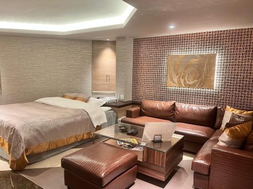 ein Hotelzimmer mit einem Bett und einer Couch in der Unterkunft Hotel Crystal Gate Nagoya - Couple Hotel in Nagoya