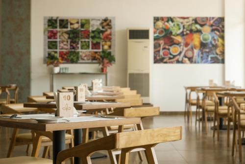 a row of tables and chairs in a restaurant at Tea Tree Suites,Manipal in Manipala