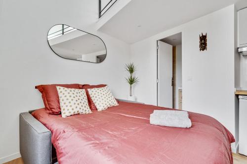 1 dormitorio con 1 cama con manta roja en Studio mezzanine 3-4 pers tout équipé Paris WIFI - R9 en Montreuil