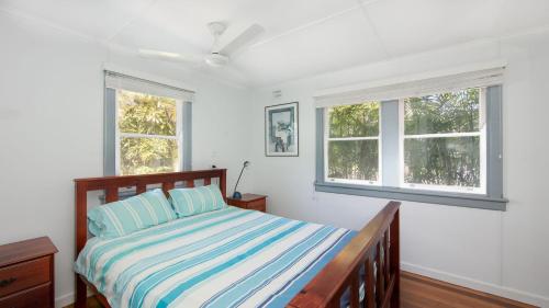 a bedroom with a bed and two windows at Koala Lodge Unit 4 in Iluka