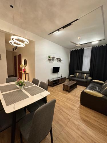 uma sala de estar com uma mesa e um sofá em The Myrini Homes - Cityview Near Drawbridge em Kuala Terengganu