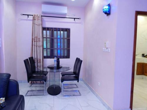 a dining room with a glass table and black chairs at Porto-Novo Charme Townhouse in Porto-Novo