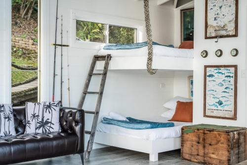 a room with two bunk beds and a ladder at The Boathouse in Daleys Point