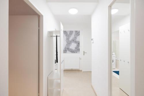 ein weißes Bad mit weißen Wänden und einem Spiegel in der Unterkunft NEW! ShalalaLiving - Lucky strike! Cozy & Homely near Schönbrunn PG20 in Wien