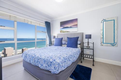 sypialnia z łóżkiem i widokiem na ocean w obiekcie Oceanview Holiday Accommodation w mieście Bloubergstrand