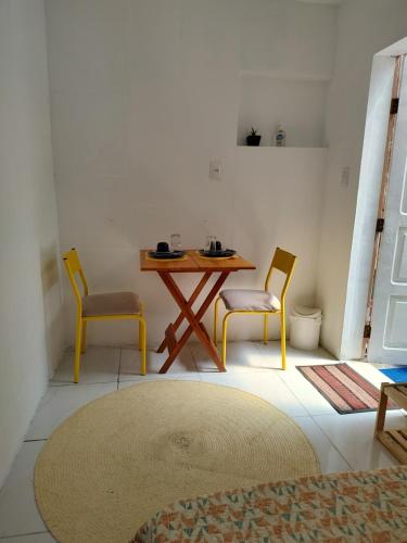 a room with a table and two chairs and a table at Suíte próxima ao Porto da Barra in Salvador