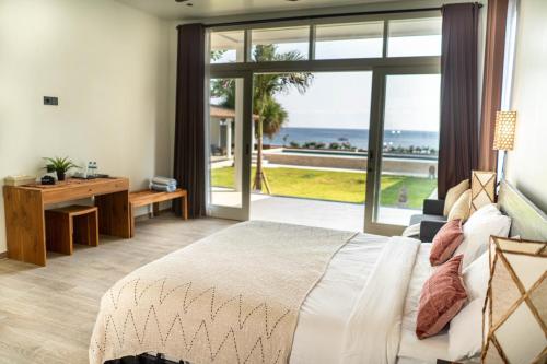 1 dormitorio con cama y vistas al océano en The Cokelat Amed, en Amed