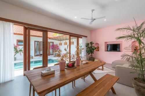 a living room with a wooden table and a pool at Charming Brand New 2BR Villa: Tranquil Canggu in Canggu