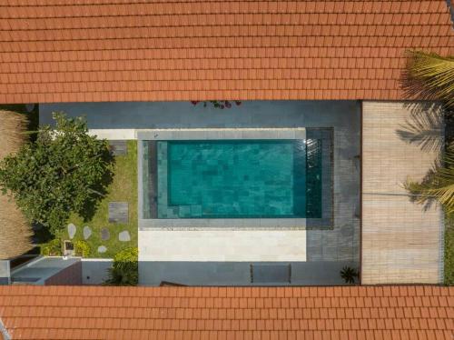 a swimming pool on the side of a building at Charming Brand New 2BR Villa: Tranquil Canggu in Canggu