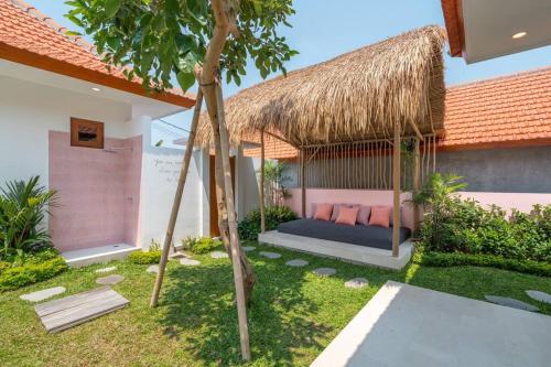 a bed in a gazebo with a straw roof at Charming Brand New 2BR Villa: Tranquil Canggu in Canggu