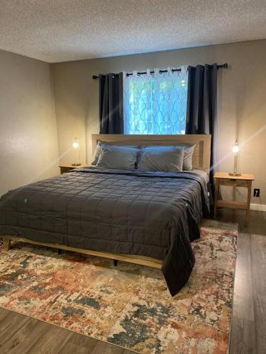 a bedroom with a bed with a window and a rug at Charming 3 Bedroom home with chimney & RV parking in East Wenatchee