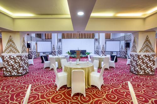a banquet hall with tables and white chairs at 1O1 URBAN Jakarta Thamrin in Jakarta