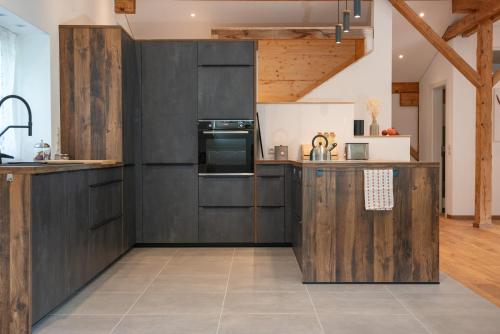 a kitchen with dark wood cabinets and a stove at 12er Huus in Bürserberg