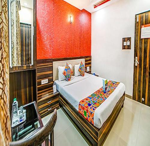 a bedroom with a bed and a chair in it at FabHotel The Adore Palace in Mumbai