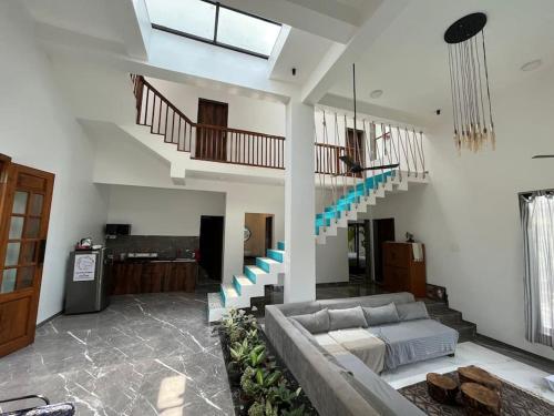 a living room with a couch and a staircase at Palm 3Bhk Villa Alibaug in Alībāg