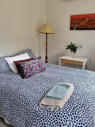 Retreat in Stirling في ستيرلينغ: سرير لحاف ازرق وبيض عليه صينية