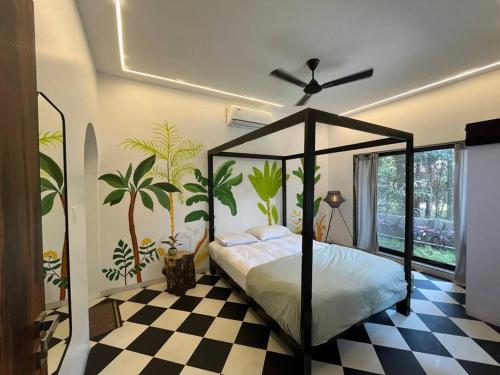 a bedroom with a canopy bed and a checkered floor at Palm 3Bhk Villa Alibaug in Alībāg